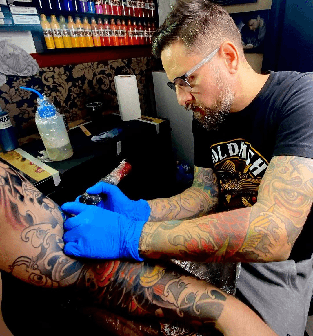 Tatuador trabajando sobre piel sintética